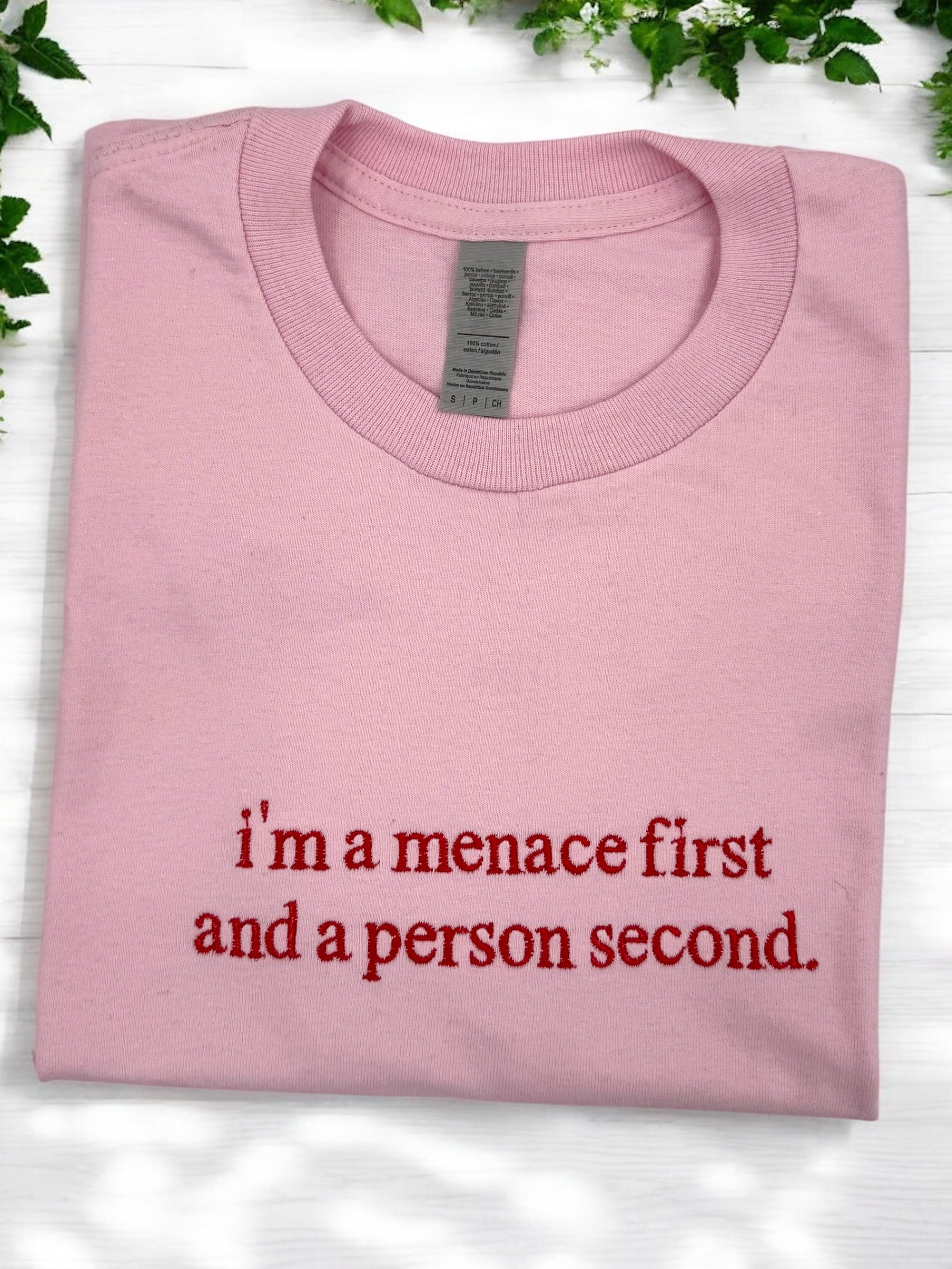 a pink shirt that says i'm a menace first and a person second