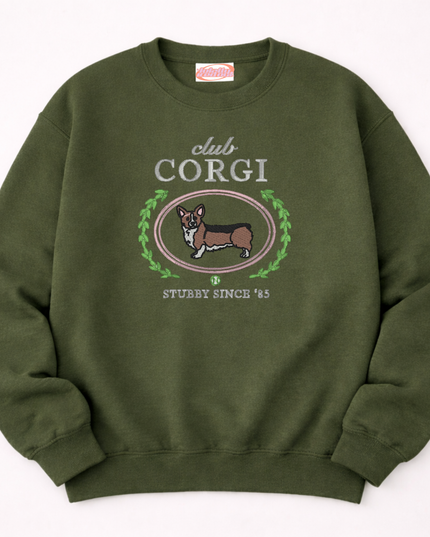 A green sweatshirt with a graphic design featuring a cartoon image of a corgi dog and the text "club CORGI" and "STUBBY SINCE '85".