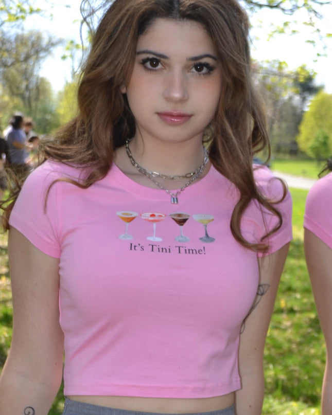 a woman in a pink shirt and a gray skirt