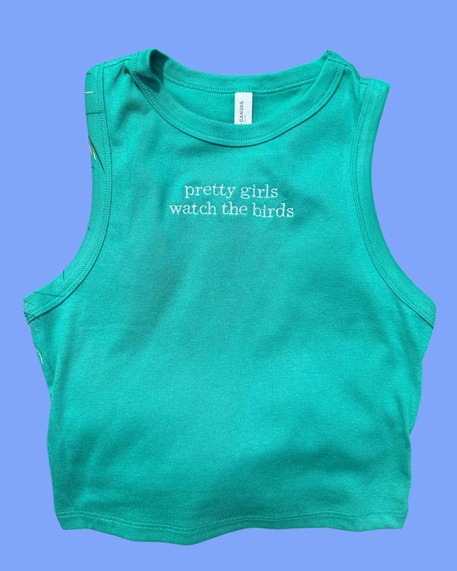 A turquoise tank top with the text "pretty girls watch the birds" printed on it.
