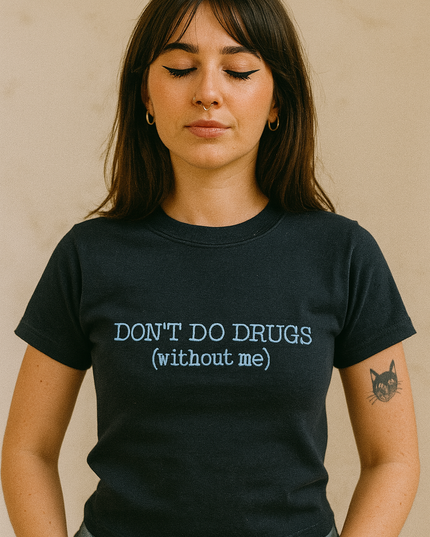 A woman wearing a black t-shirt with the text "DON'T DO DRUGS [without me]" printed on it.