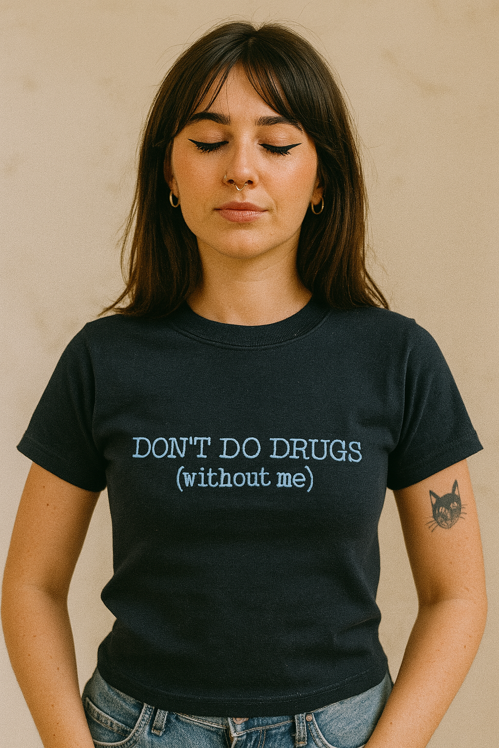 A woman wearing a black t-shirt with the text "DON'T DO DRUGS [without me]" printed on it.