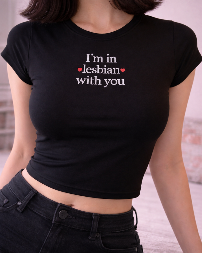 A woman wearing a black crop top with the text "I'm in Lesbian with you" printed on it.