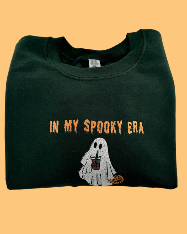 a green shirt with a ghost holding a drink