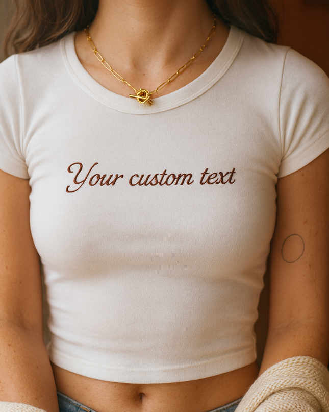 A woman wearing a white crop top with the text "Your custom text" printed on it.