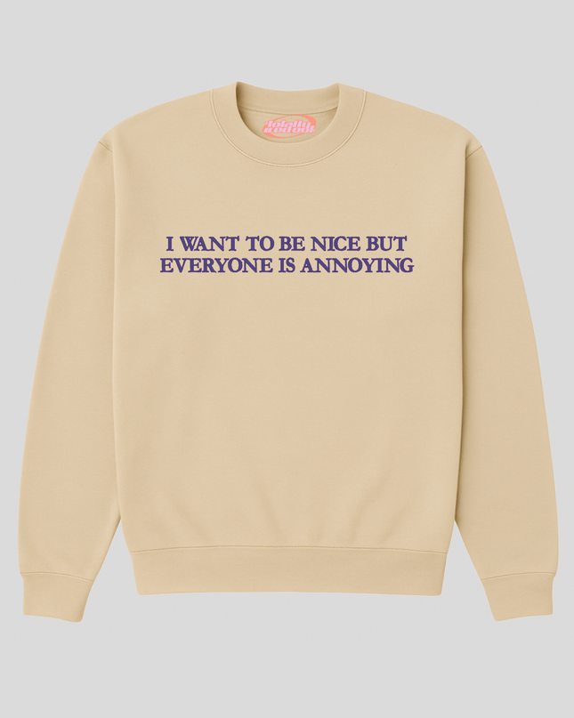 A beige sweatshirt with the text "I WANT TO BE NICE BUT EVERYONE IS ANNOUNCING" printed on it.