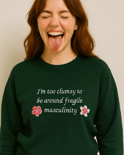 A woman with long brown hair wearing a green sweatshirt with text on it.