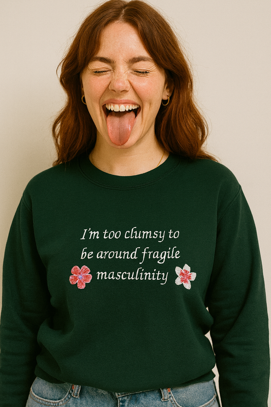 A woman with long brown hair wearing a green sweatshirt with text on it.