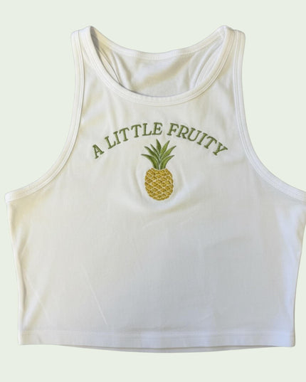 A white crop top with a pineapple embroidered on it, and the text "A LITTLE FRUITY" printed on it.