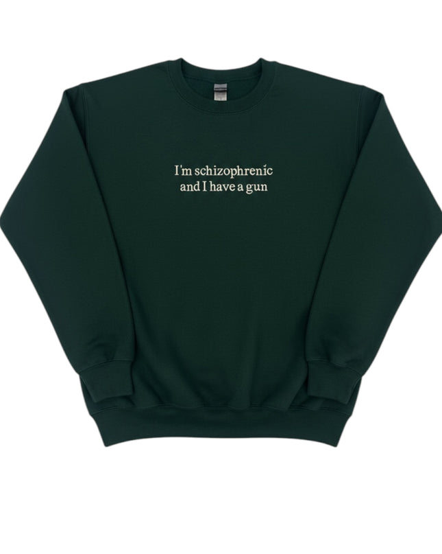 A dark green sweatshirt with the text "I'm schizophrenic and I have a gun" printed on it.