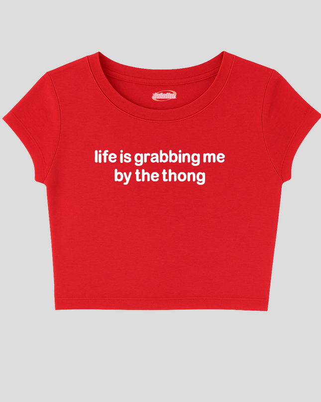 A red cropped top with the text "life is grabbing me by the thong" printed on it.