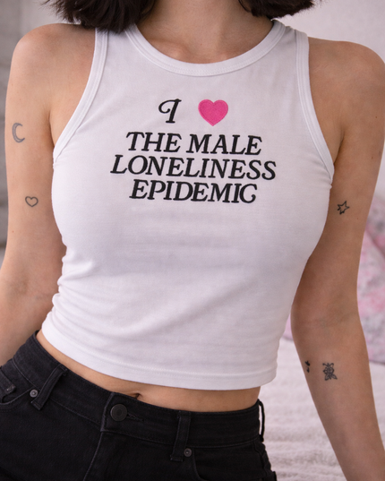 A woman wearing a white tank top with text printed on it.