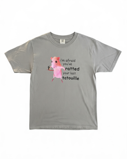 A gray t-shirt with a graphic design depicting a pink pig and text that reads "I'm afraid you've ratted your last tatouille".