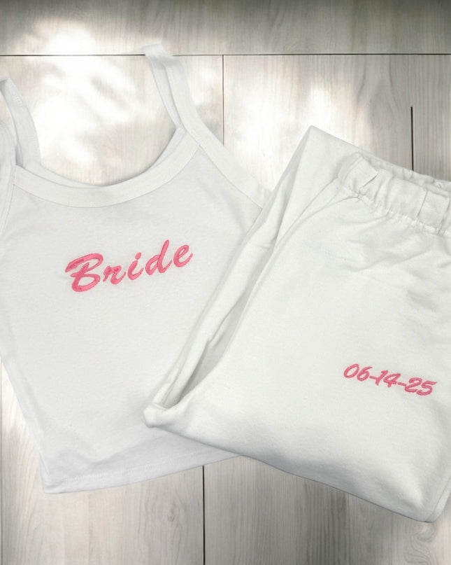 a white tank top with a pink bride embroidered on it