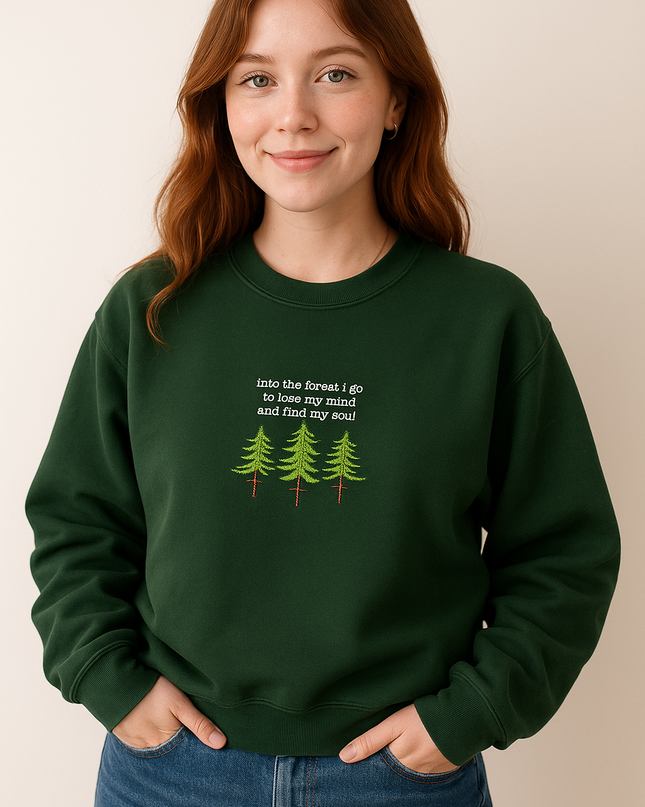 A young woman with red hair wearing a green sweatshirt with a text design on it.