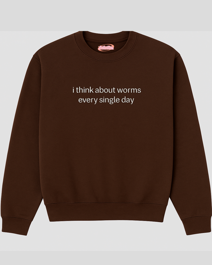 A brown sweatshirt with the text "I think about worms every single day" printed on it.