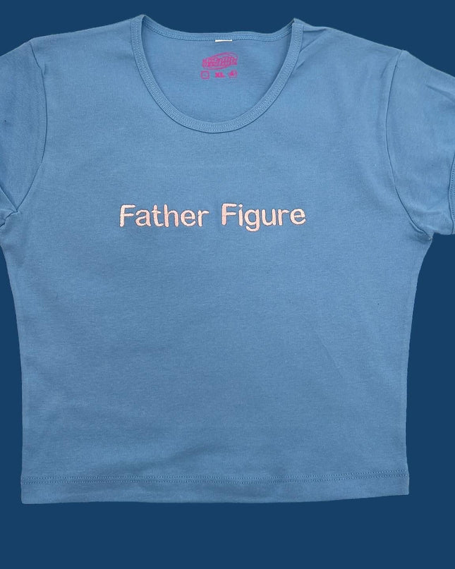 A light blue t-shirt with the text "Father Figure" printed on it.
