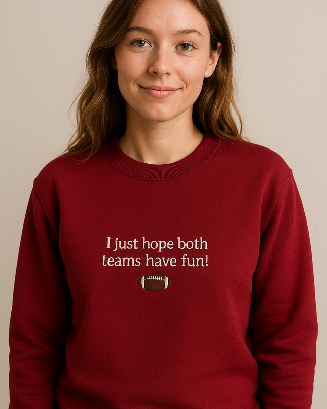 A woman wearing a red sweatshirt with the text "I just hope both teams have fun!" printed on it.