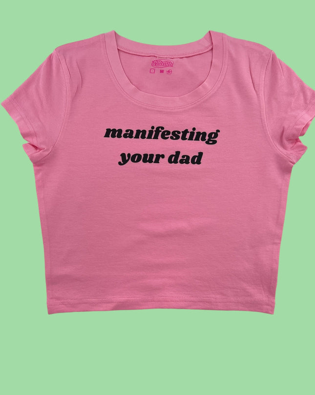 a pink crop top with the words manifisting your dad printed on it