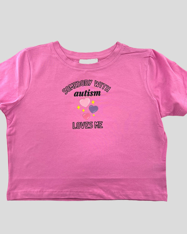 a pink t - shirt with the words autism loves me on it