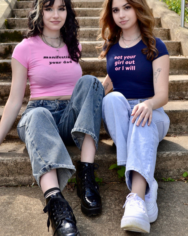 two young women sitting on the steps of a set of stairs