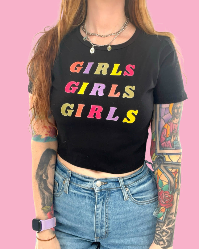 a woman wearing a black shirt with the words girls girls on it