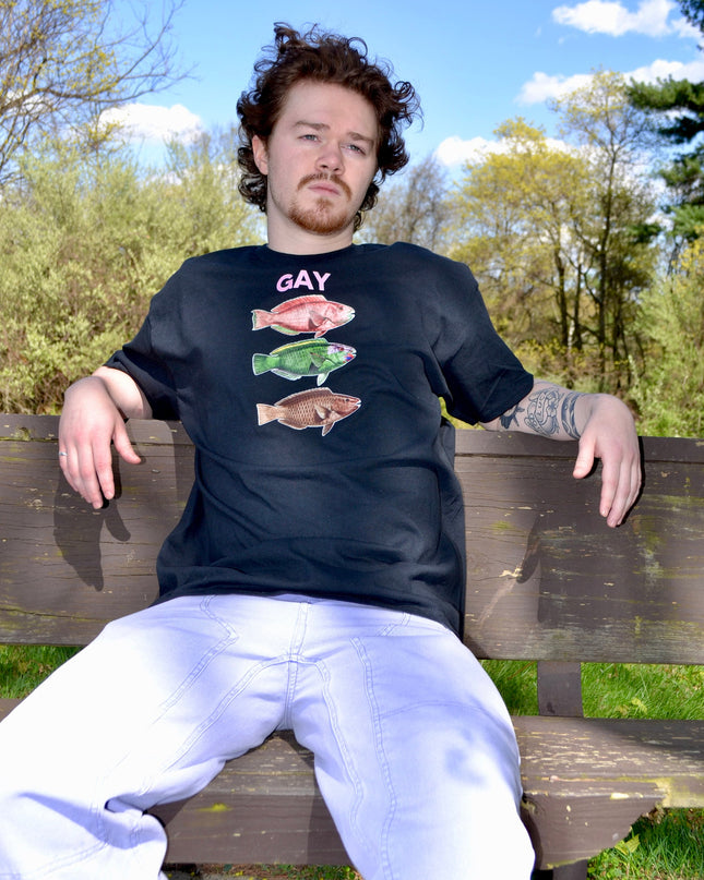 a man sitting on a wooden bench in a park