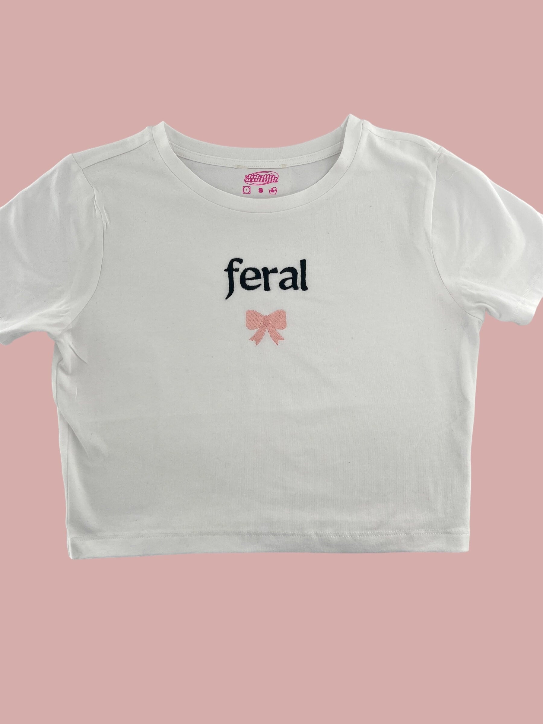 a white crop top with a pink bow on the chest
