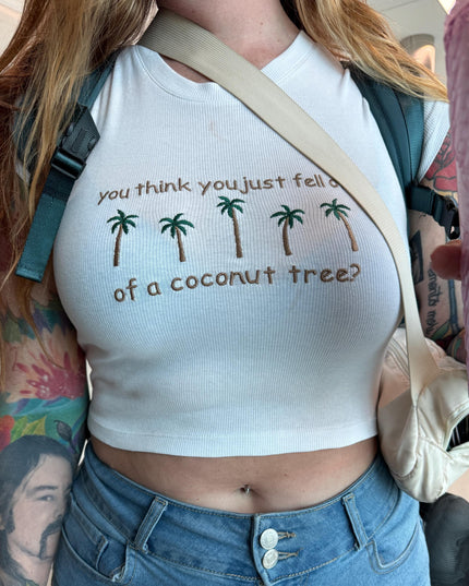a woman wearing a white shirt with palm trees on it