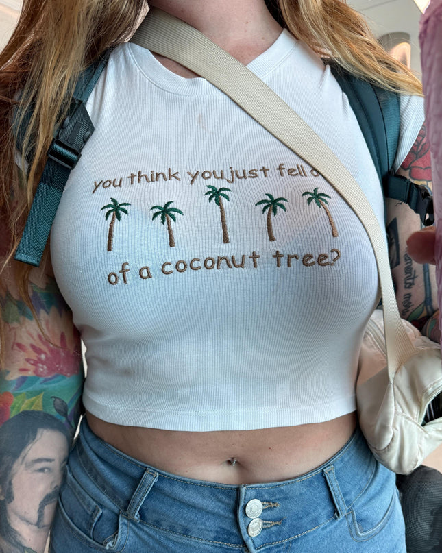 a woman wearing a white shirt with palm trees on it