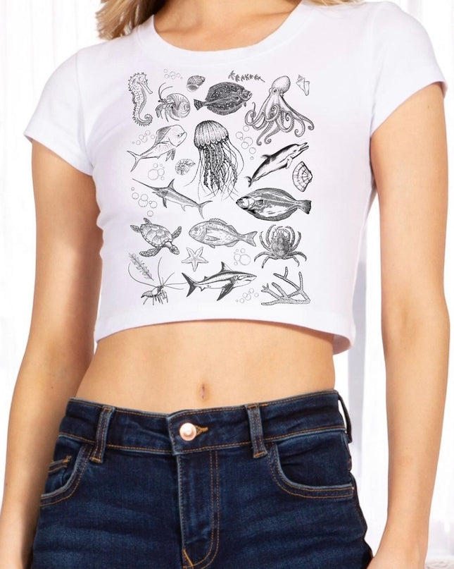 a woman wearing a white crop top with a drawing of sea animals on it