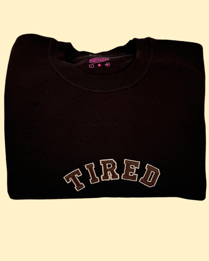 a black shirt with the word tired on it