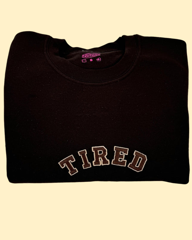 a black shirt with the word tired on it