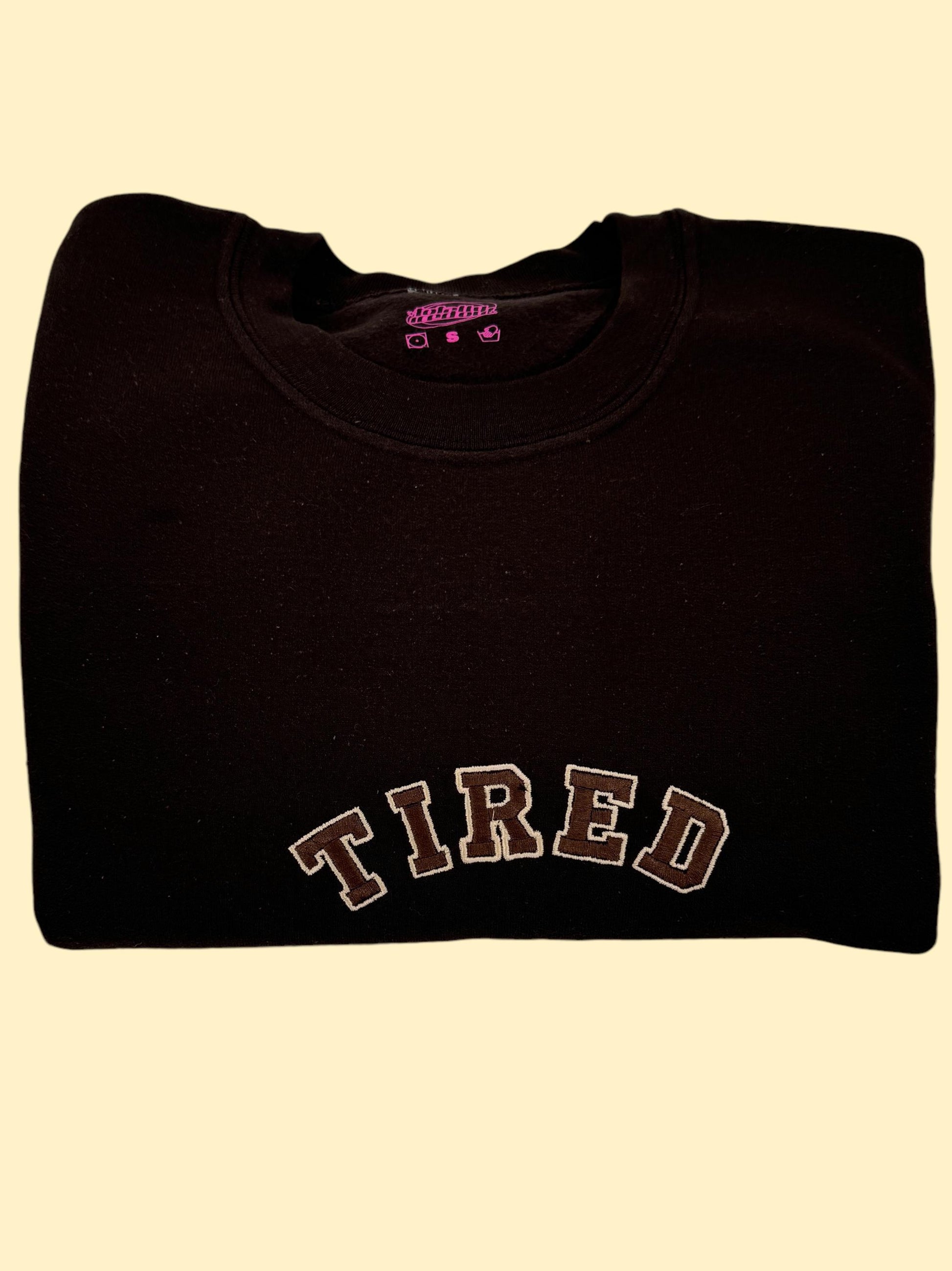 a black shirt with the word tired on it