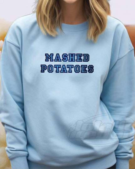 a woman wearing a blue sweatshirt that says mashed potatoes