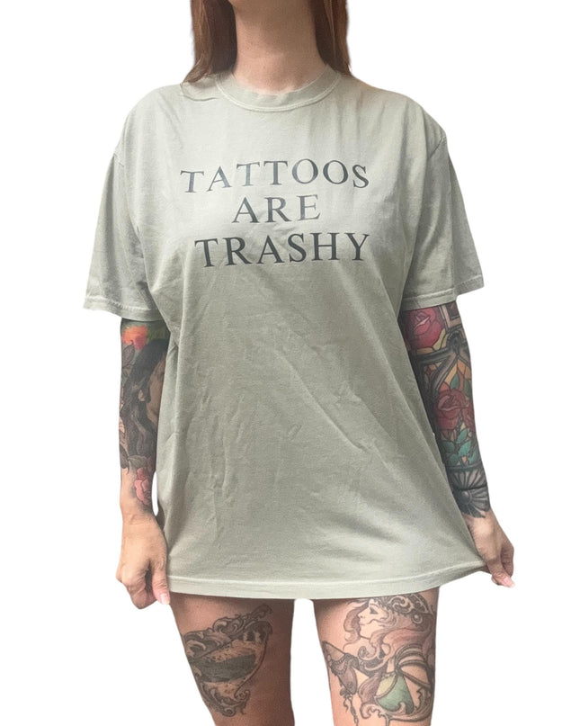 a woman with tattoos on her legs wearing a shirt that says tattoos are trashy