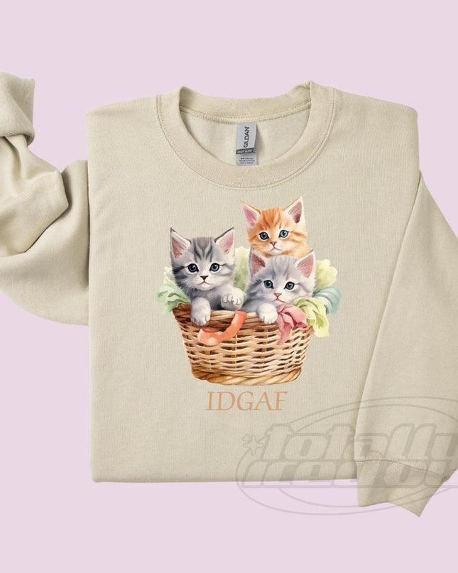 a sweater with a picture of three kittens in a basket