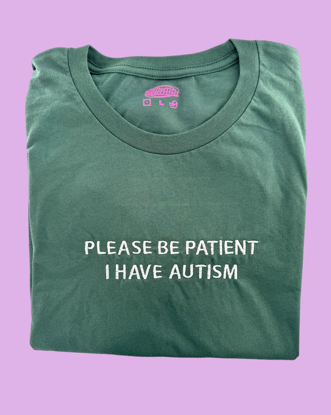 a green t - shirt that says please be patient i have autism