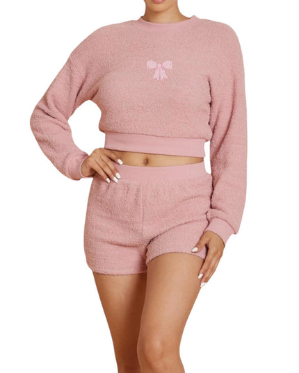 a woman wearing a pink sweater and shorts