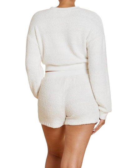 a woman wearing a white sweater and shorts