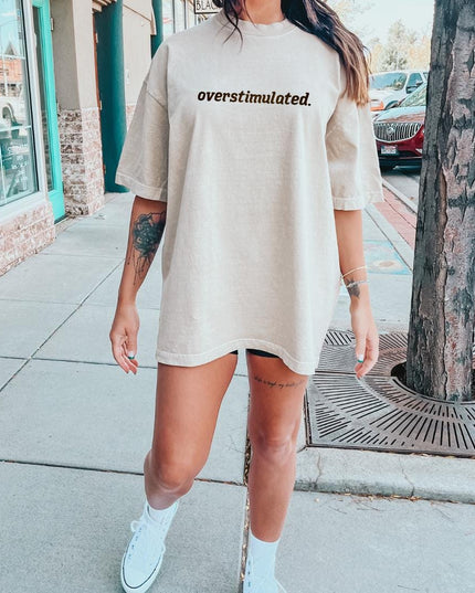 a woman in a white shirt and shorts standing on a sidewalk