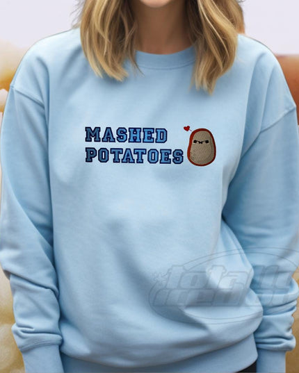 a woman wearing a blue sweatshirt that says mashed potatoes