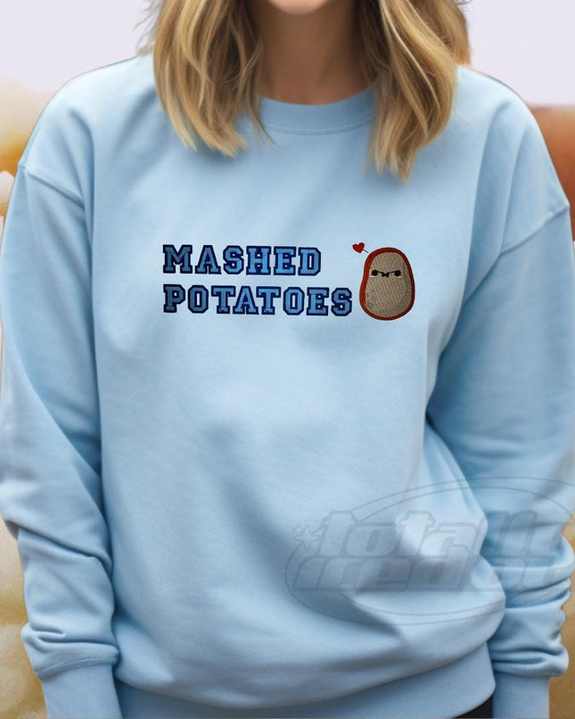 a woman wearing a blue sweatshirt that says mashed potatoes
