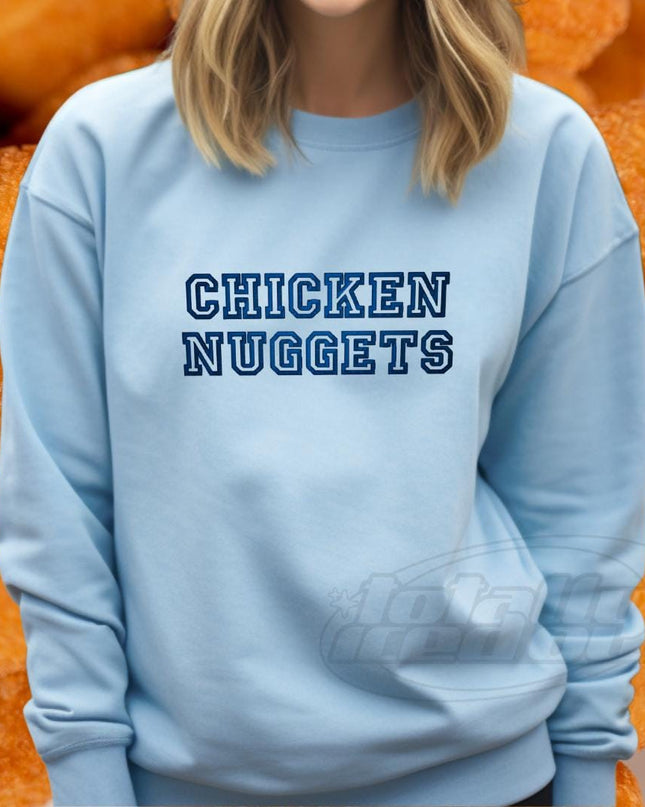 a woman wearing a blue sweatshirt with the words chicken nuggets on it