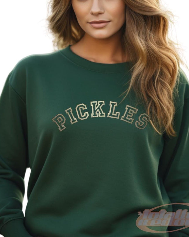 a woman wearing a green sweatshirt with the word pickles on it