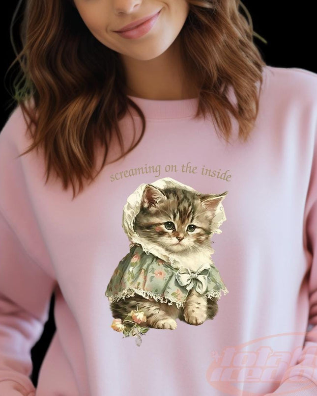 a woman wearing a pink sweatshirt with a cat on it