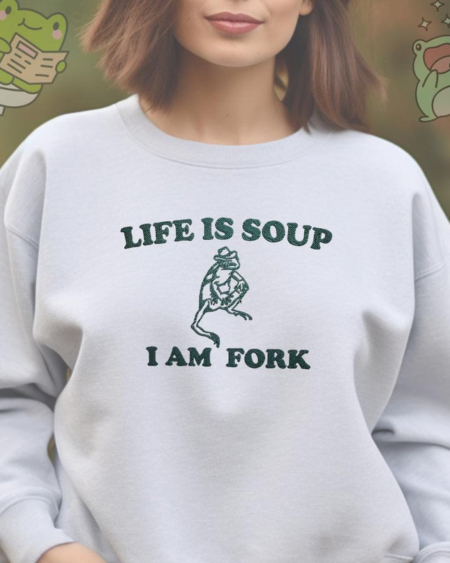 a woman wearing a sweatshirt that says life is soup i am fork