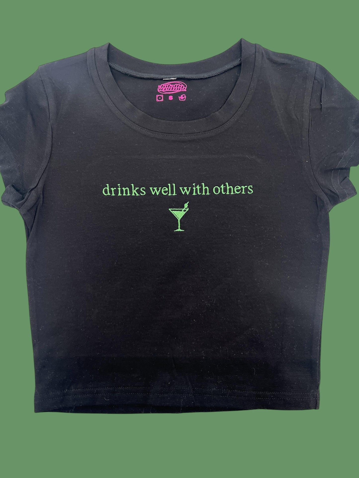 a black t - shirt with the words drinks well with others