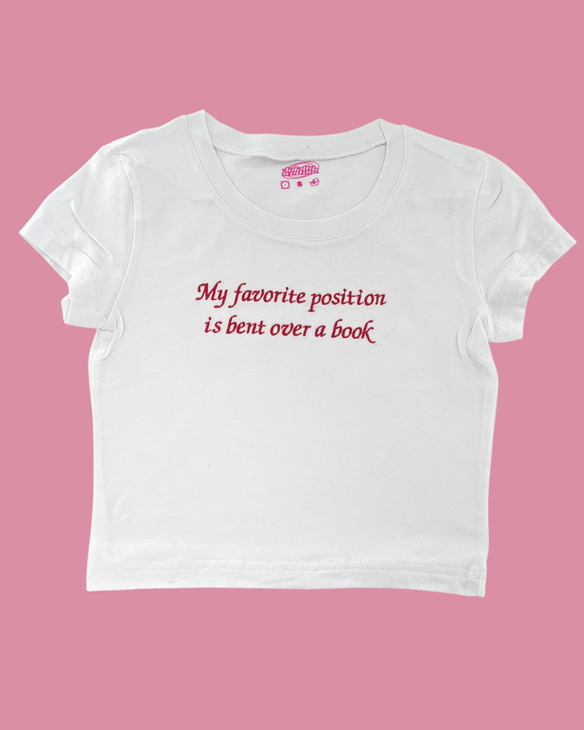 a white t - shirt that says, my favorite position is bent over a book