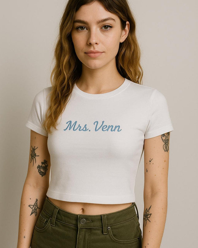a woman with a tattoo on her arm wearing a white shirt